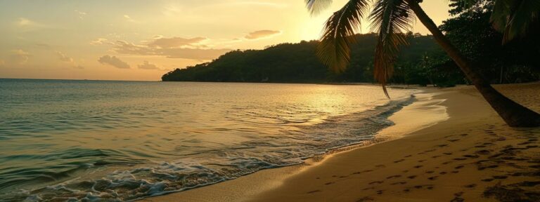 A serene beach at sunset with gentle waves and a silhouette of a hillside in the distance.